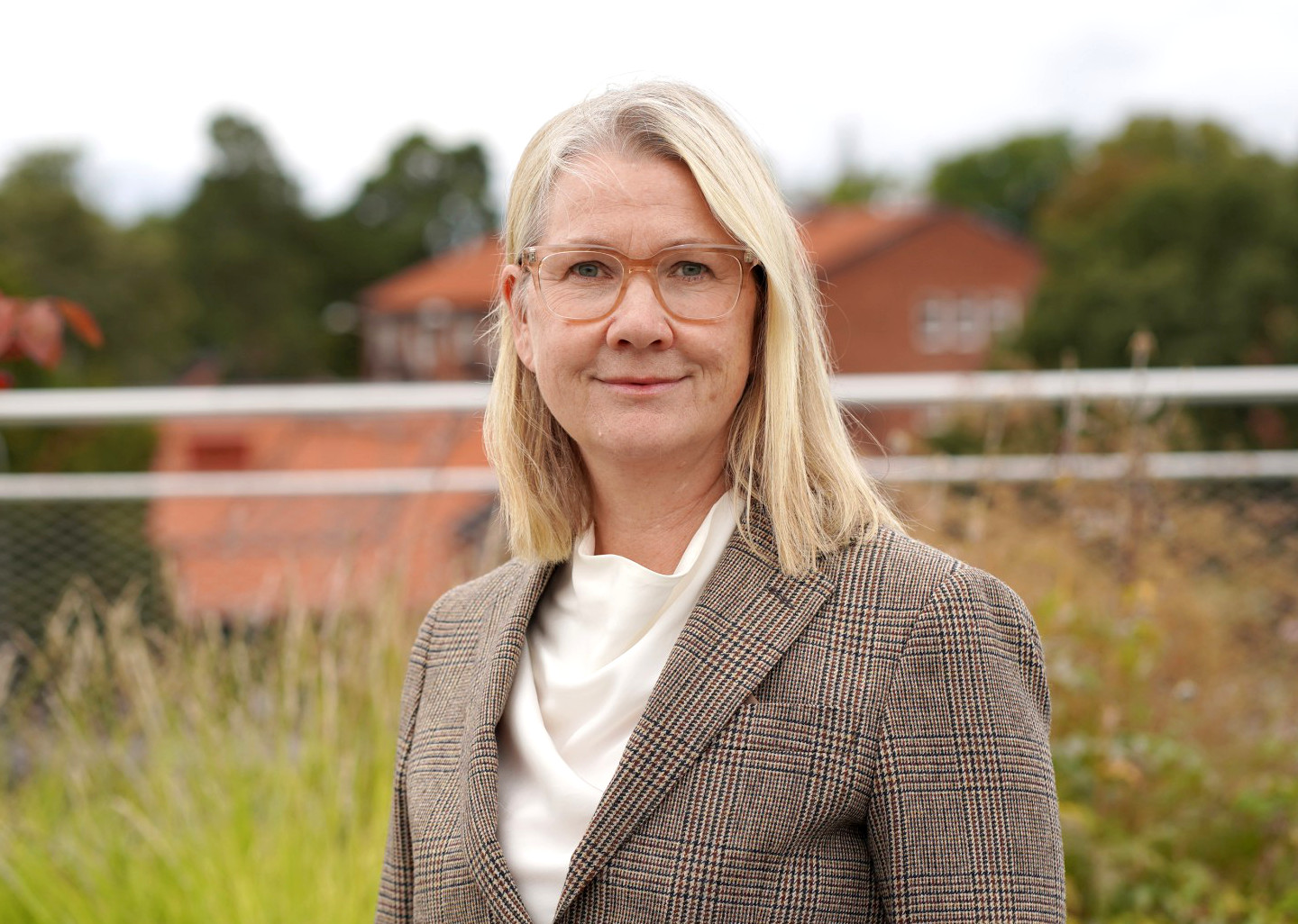 Professor Karin Berglund vid Stockholms universitet står utomhus och tittar in i kameran.