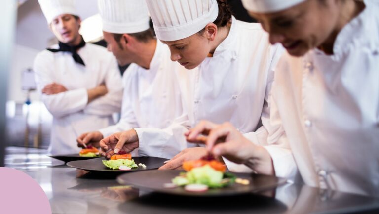A group of star chefs practicing putting food on a plate.