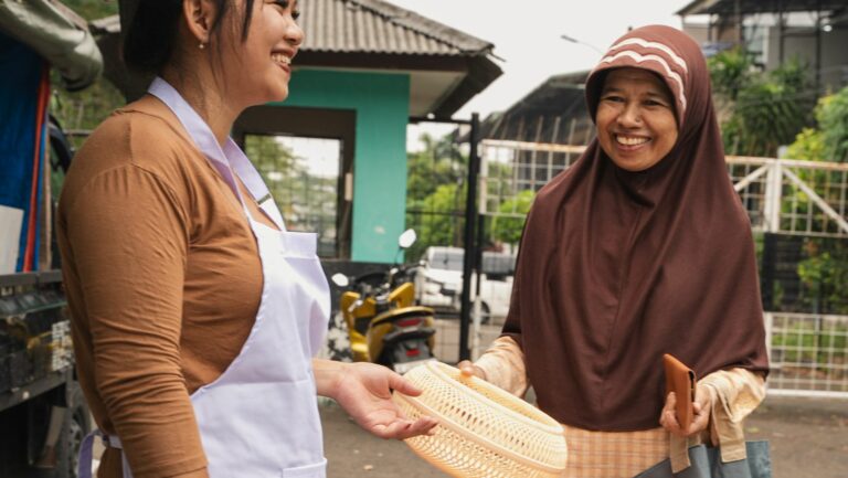 Two women are selling goods to each other.