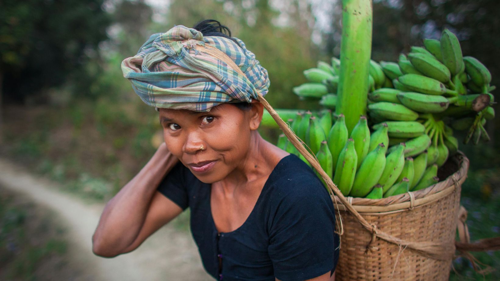 Female entrepreneur carrying bananas on her back.